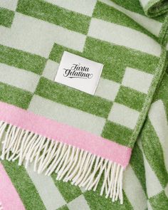 a green and pink checkered blanket with a label that says prima flania