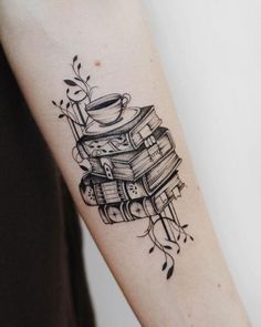 a tattoo on the arm of a woman with books and a coffee cup in it