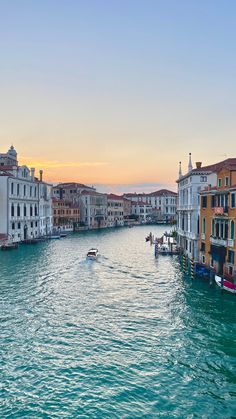 the sun is setting in venice, italy as boats travel through the water and buildings on both sides