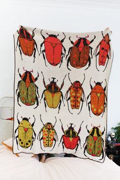 a blanket with different colored bugs on it