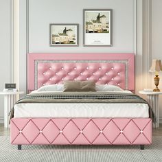 a bed with pink upholstered headboard and foot board in a white room