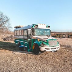 a bus parked in the middle of a field with no grass on it's side