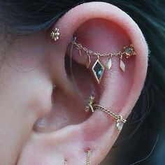 the ear is adorned with gold chains and charms