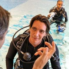 two men in scuba suits talking to each other