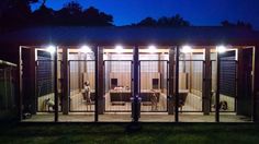 an enclosed patio area at night with lights shining on the doors and table in the background