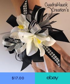 a wrist corsage with white flowers and black ribbon