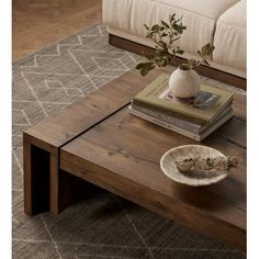 a coffee table with books and a vase on it