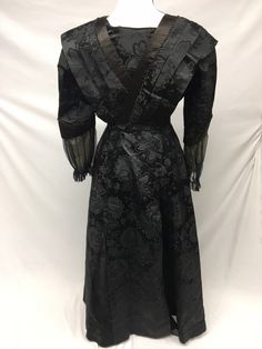 "1900s Edwardian Petite Black Silk Jacquard woven Taffeta Mourning Dress AS IS - FOR STUDY, Museum Deaccession Cannot be worn - Dress is a jacquard woven Black Silk Taffeta - A folded piece of Beige Crepe de Chine fabric has been tacked into front (not original) - Sleeves and edges are solid black silk satin - Sleeve cuffs are trimmed in black Silk crinkle chiffon, lined with beige birds eye netting - Bodice is lined in a heavy cotton chintz, which has stays and hook/eye closures in front - Deep Vintage Brocade Victorian Dress For Costume, Black Victorian Dress With Fitted Bodice, Vintage Brocade Victorian Dress, Vintage Brocade Dress With Historical Design, Elegant Victorian Brocade Dress With Historical Design, Victorian Style Vintage Dress For Evening, Victorian Vintage Dress For Evening, Fitted Black Dress With Historical Design, Fitted Black Dresses With Historical Design