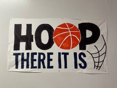 a sign that says hoop there it is hanging on the wall next to a basketball