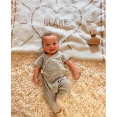 a baby laying on the floor next to a blanket that says, i love you