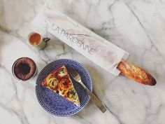 a piece of pizza sitting on top of a blue plate next to a knife and fork