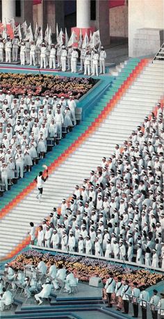 a large group of people standing on top of a stage next to each other in front of a crowd