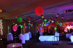 a room filled with lots of balloons and tables