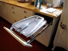 an open drawer in the middle of a kitchen with utensils and knives on it