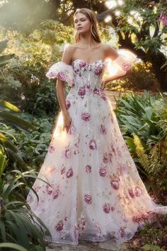 a woman in a floral dress posing for the camera with her hands on her hips