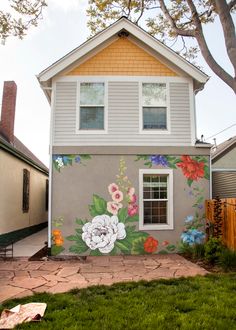 a house with flowers painted on the side of it