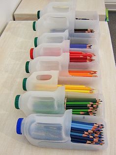 a row of plastic containers filled with colored pencils on top of a wooden table