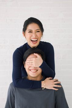 a man is holding his head on the back of a woman's shoulders and smiling