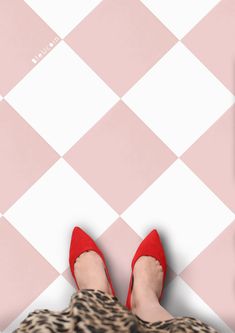 a woman's feet in red shoes on a pink and white checkered floor