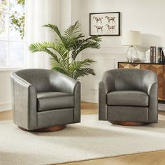 two gray chairs sitting on top of a white rug