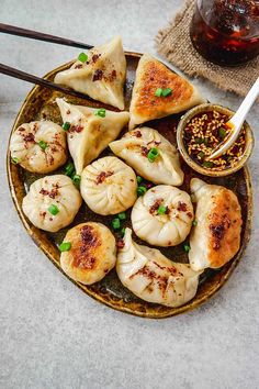 some dumplings are sitting on a plate with dipping sauce