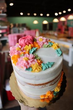 a person holding a cake with flowers on it