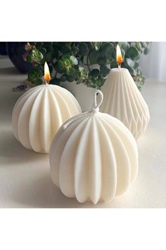 three white candles sitting on top of a table