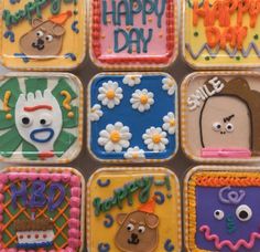 decorated cookies are arranged in the shape of cartoon faces and words that spell happy day