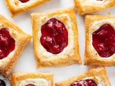 small pastries with jam on them are arranged on a white surface and ready to be eaten