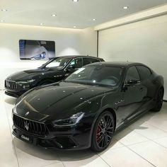 two black masera cars in a showroom