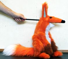 a stuffed fox is being held by a person