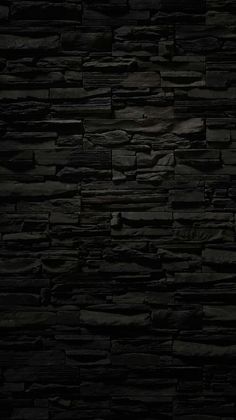 a black stone wall with no mortars or mortars on it in the dark