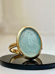 "Out of passion I'm engraving gemstones with all kinds of symbols and idols. Here I'm offering a bespoke intaglio ring engraved with the image of a mythological mermaid or siren that I designed. Please choose your desired metal from the dropdown menu as well as your ring size. Please add the stone colour you like under \"personalisation\"." Luxury Sterling Silver Engraved Intaglio Ring, Luxury Artisan Jewelry With Intaglio, Luxury Fine Jewelry With Intaglio Details, Luxury Fine Jewelry With Intaglio, Luxury Intaglio Ring Jewelry, Luxury White Intaglio Rings, Luxury Timeless Intaglio Ring, Luxury Women's Intaglio Rings, Intaglio Ring Jewelry