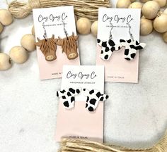 three pairs of cow earrings are on display