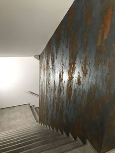 an old rusted metal wall next to some stairs