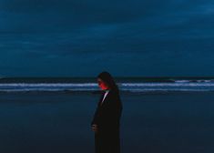 a woman standing on the beach at night