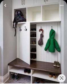 a coat rack with two coats hanging on it's sides and shoes in the closet