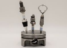 an engine piston and two spark plugs are shown in this miniature model, which is also part of the kit