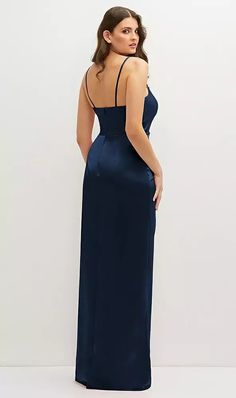 a woman in a long blue dress is looking back at the camera and she has her hands on her hips