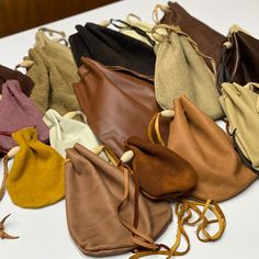 a bunch of purses sitting on top of a white table next to each other