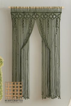 a green curtain hanging on the wall next to a cactus