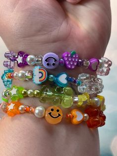 Channel your inner 90s Y2K self!  Our funnest bracelet stack yet. Layer them all together or wear them individually. The choice is yours! No two are the same so each piece you receive is one of a kind! Adorned with resin gummy bears, glass pearls, plastic smiley faces, clay fruit, glass seed beads, and many other fun novelties! Purchase as a set of 4 or select just one in your favorite color combination.  The nostalgic vibe you will get from these will be totally awesome!  *Bracelets pictured ma Bracelet Resin, Clay Rainbow, Candy Rainbow, Diy Kandi Bracelets, Diy Kandi, Candy Bracelet, Kandi Ideas, Rainbow Stars, Nostalgia Aesthetic