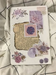 an altered photo with flowers and other things on top of the paper, sitting on a bed sheet