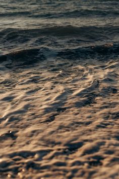 the surf is coming in and out of the water at sunset or sunrise on the beach