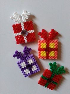 three pieces of bead art sitting next to each other on a white table top