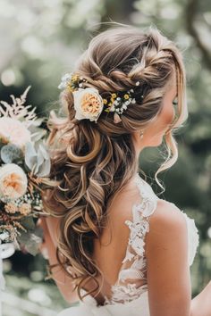 a woman with long hair and flowers in her hair is looking down at the ground