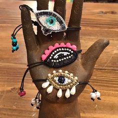 the hand is decorated with beads and other things on it's palm, which includes an evil eye