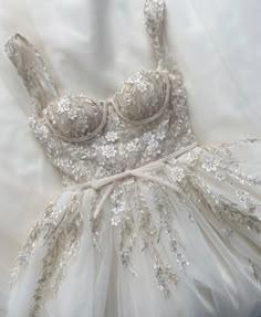 the dress is white with silver flowers on it