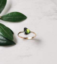 Stunning rose cut teardrop green Tourmaline gemstone set in a sterling silver bezel and finished with a 14k gold filled band. This beautiful ring makes a great gift for someone special or yourself. D E T A I L S . . . . . . . .  Metal: Sterling Silver & 14k Gold Filled Gemstone: Tourmaline  Size: 7 US Please feel free to contact us if you need another size. Handmade jewelry with Love and Passion by Grace Lilly Designs. Handcrafted in the USA. Green Solitaire Teardrop Jewelry, Green Teardrop 14k Gold Ring, Green Teardrop Jewelry With Bezel Setting, Green Tourmaline Teardrop Jewelry, Pear-shaped Tourmaline Jewelry As A Gift, Pear-shaped Tourmaline Jewelry Gift, Pear-shaped Tourmaline Jewelry For Gift, Gift Pear-shaped Tourmaline Jewelry, Silversmith Rings