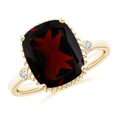 a gold ring with a red star on the center and two white diamonds around it